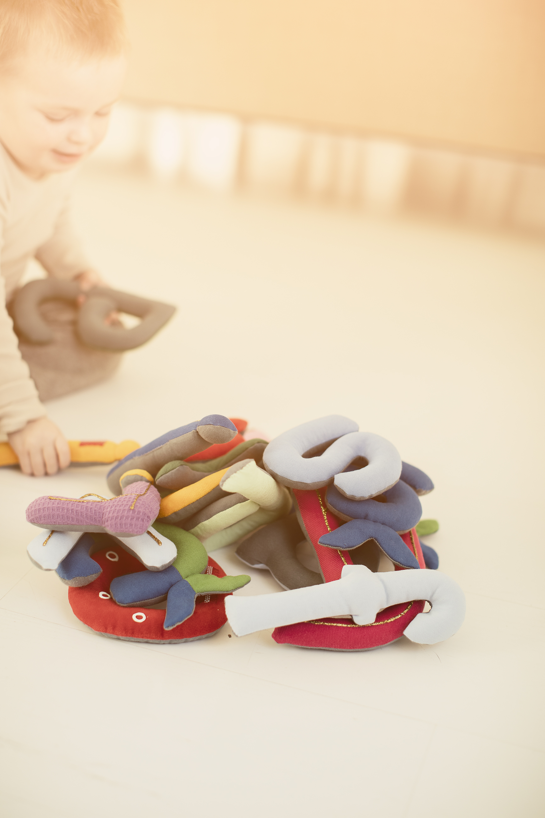 Mánná ja bustávvaguhpa. Barn og haug av bokstaver.